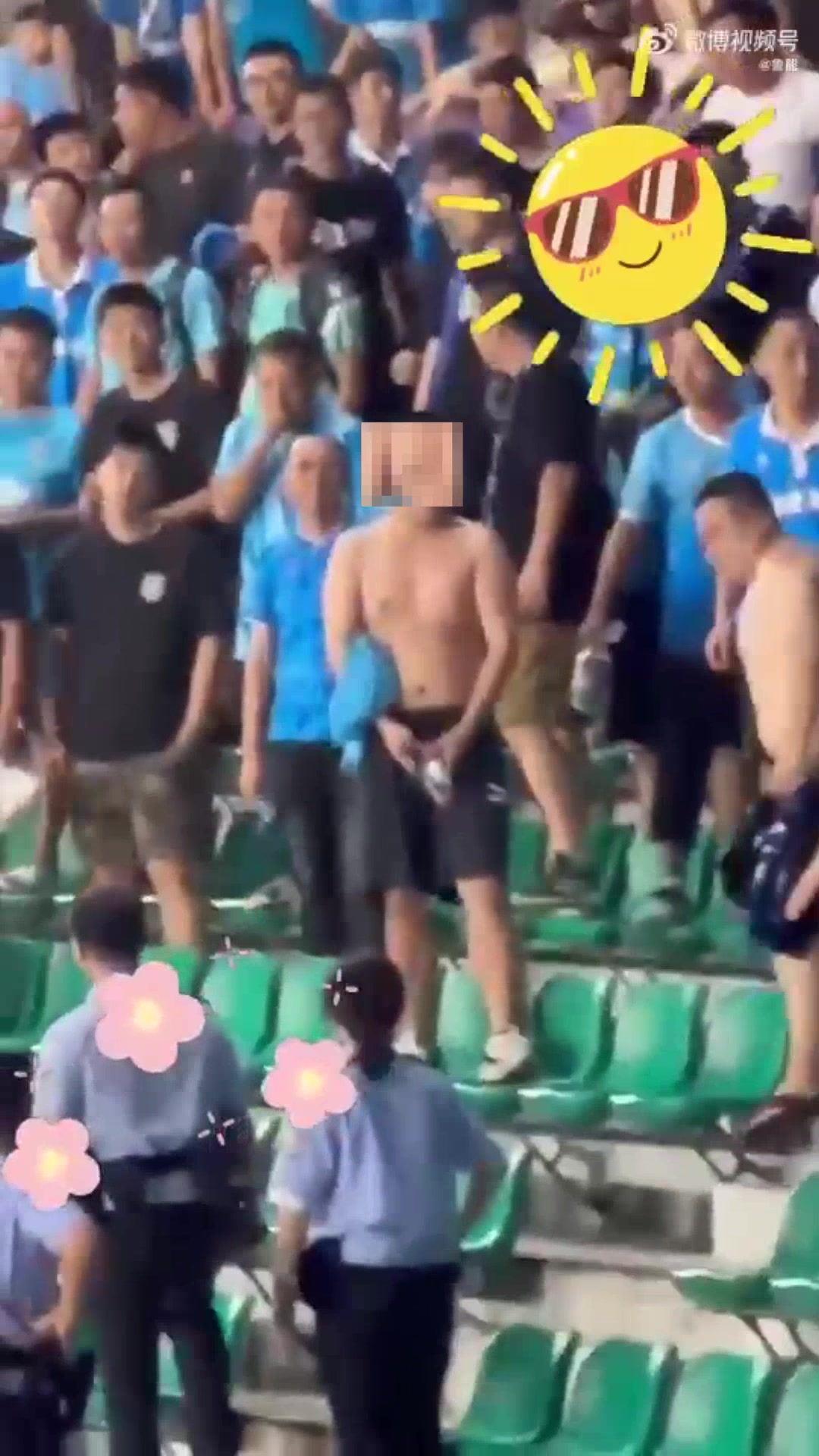 一位拿水瓶做下流动作的南通球迷