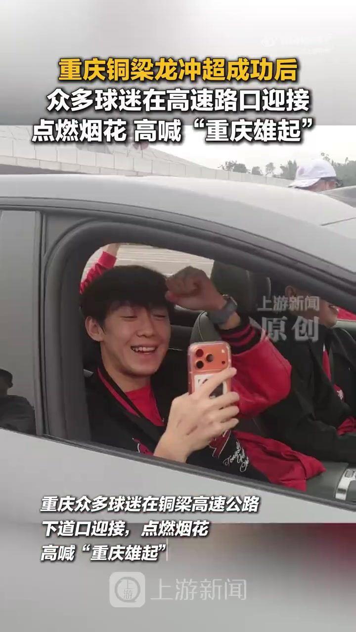 众多球迷在高速路口迎接重庆铜梁龙，点燃烟花高喊“重庆雄起”