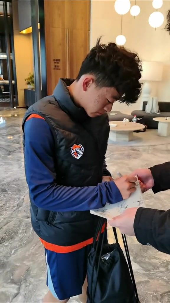 U17国脚邝兆镭为球迷签名，他已参加青岛海牛合练